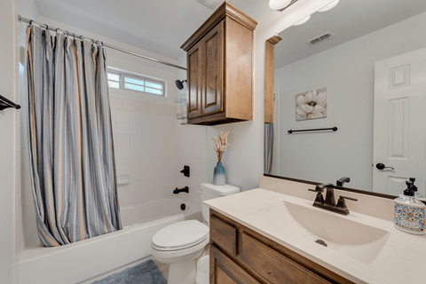 a bathroom with a sink toilet and shower and a shower curtain