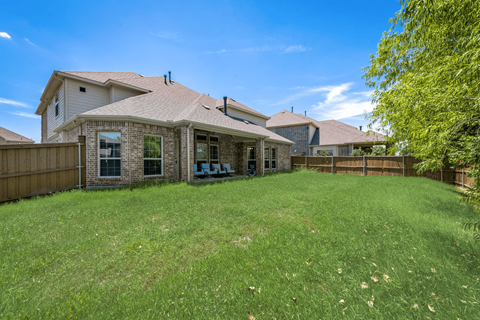 a backyard with a house and a fence