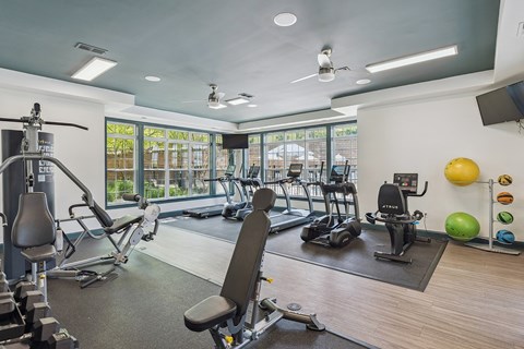 a gym with weights and other exercise equipments and a window