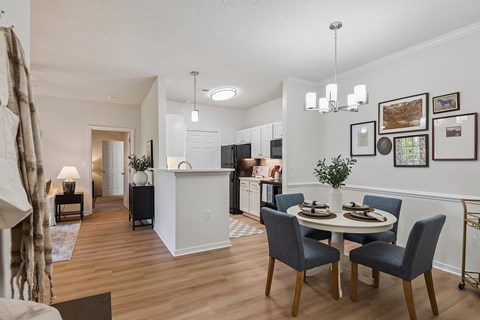 A dining room with a white table and chairs.