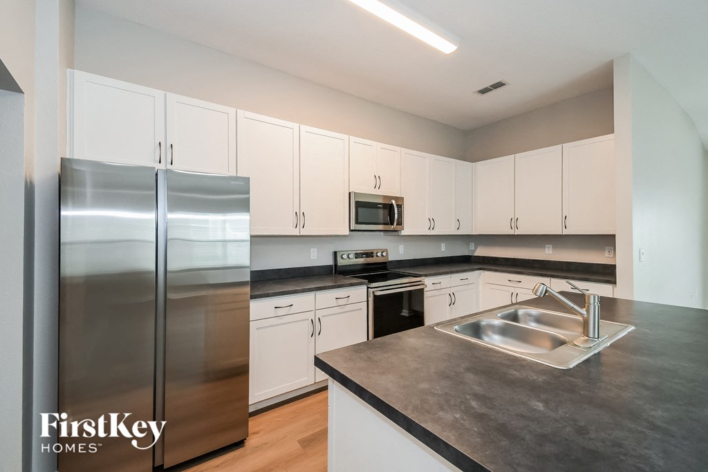 a kitchen with white cabinets and stainless steel appliances