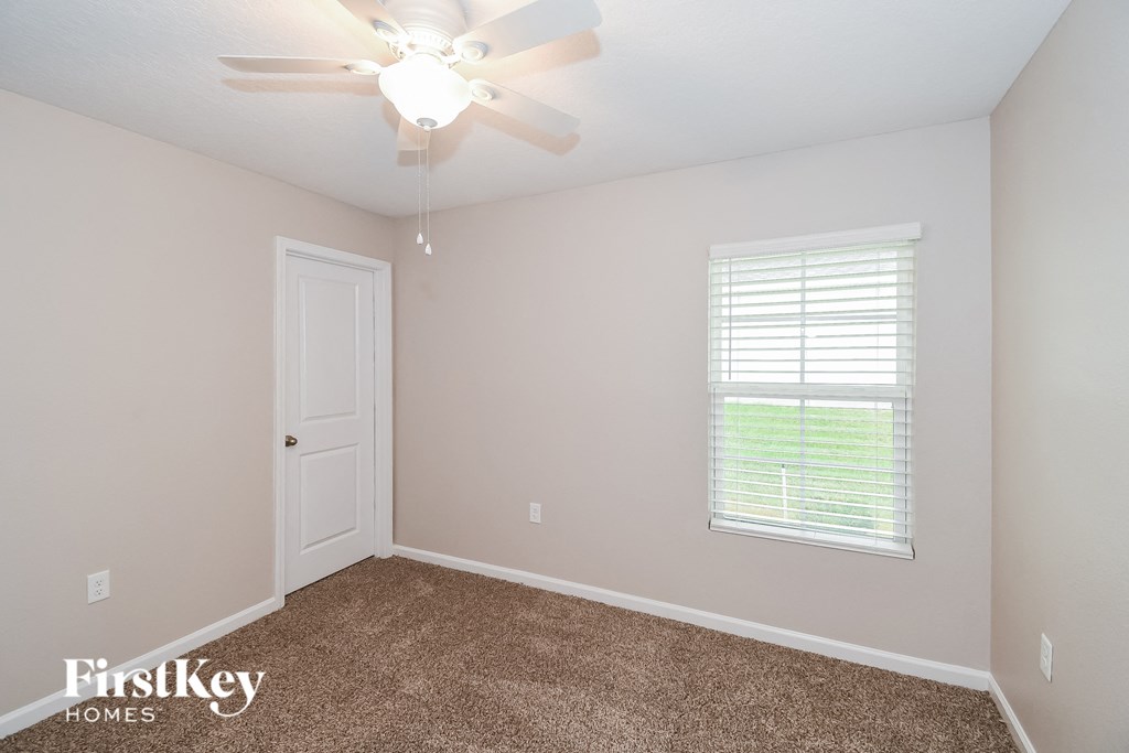 a bedroom with a ceiling fan and a window