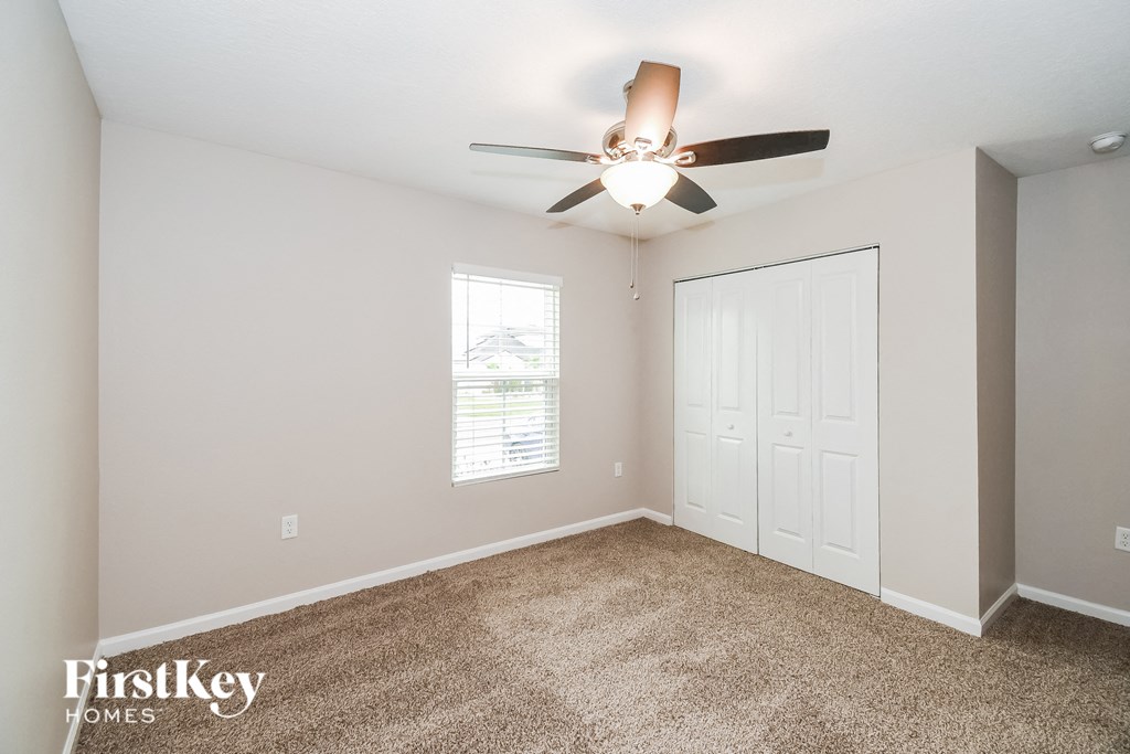 a bedroom with a ceiling fan and a closet