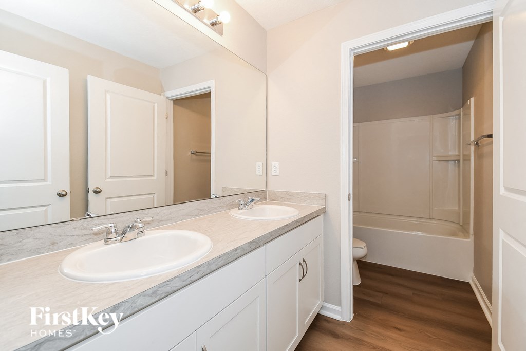 a bathroom with two sinks and a shower and a mirror