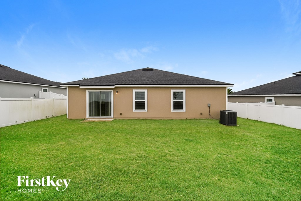 a backyard with a house and a green lawn