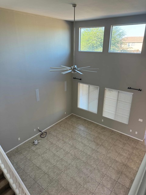 a living room with a ceiling fan and a tiled floor