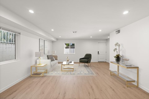 A living room with a black chair and a white sofa.