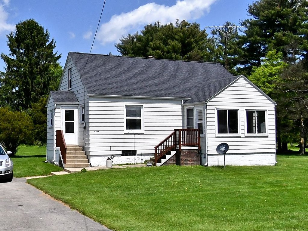 a white house with a porch and a yard