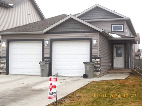 A house with a garage door that is for rent.