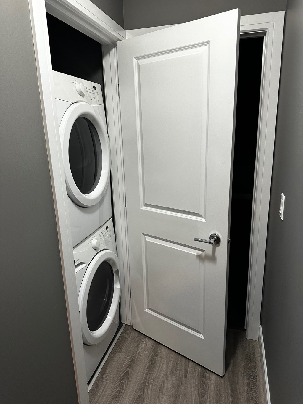 A white door is open to reveal a washing machine.