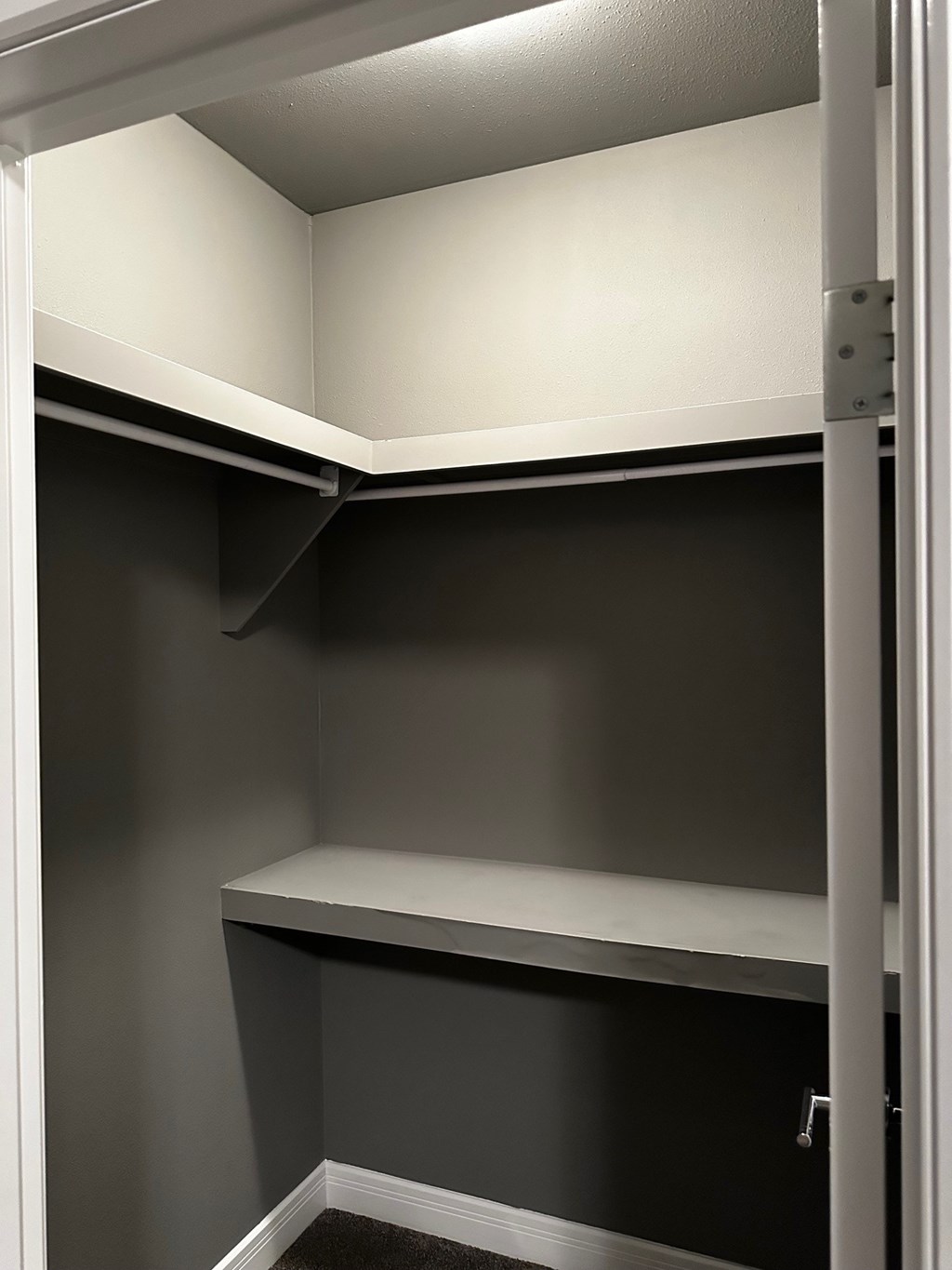 A white shelf in a grey pantry.