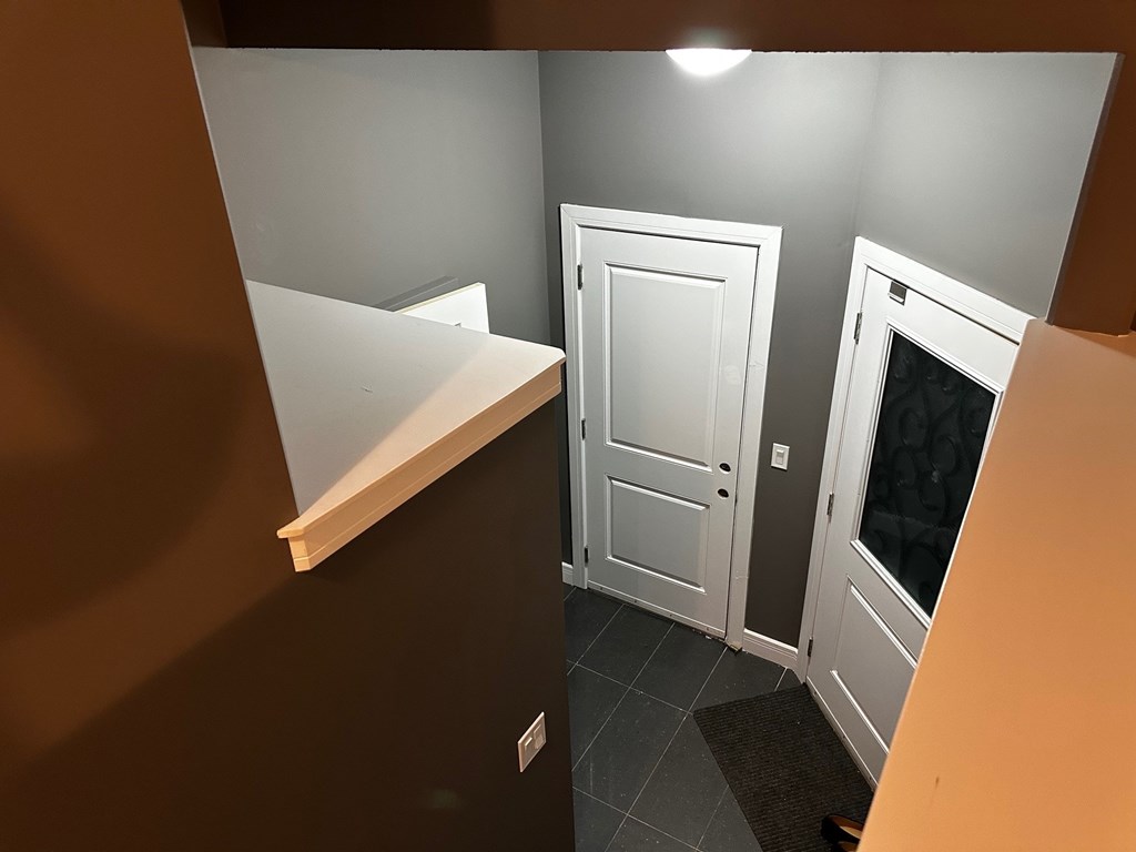 A white door is in the middle of a hallway.