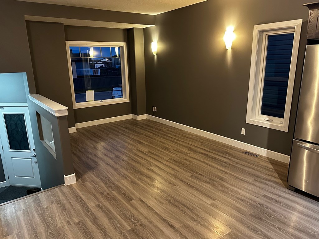 A kitchen with a wooden floor and a window.