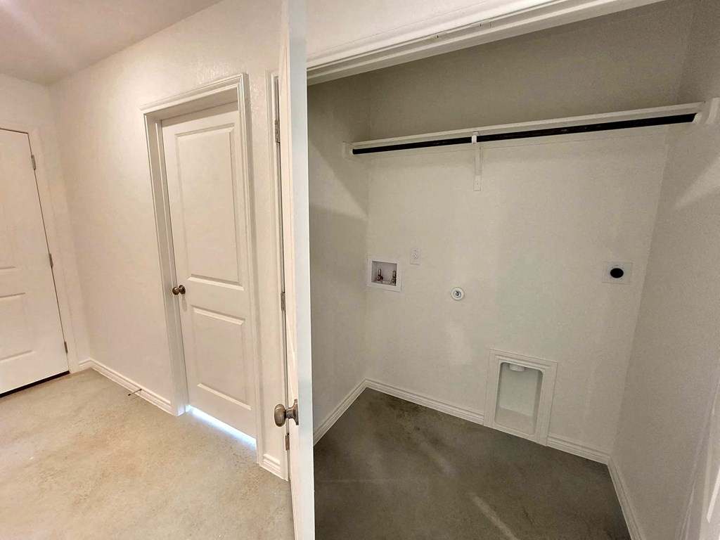 a room with a white door and a hallway with a garage door