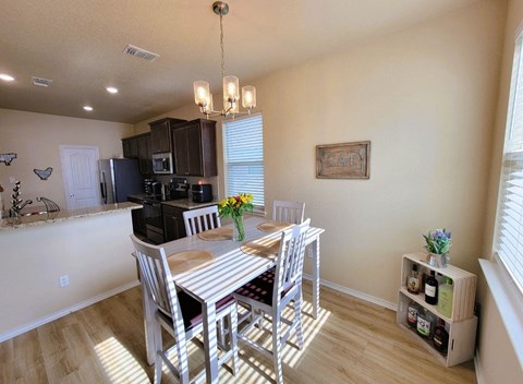a dining room and kitchen with a table and chairs