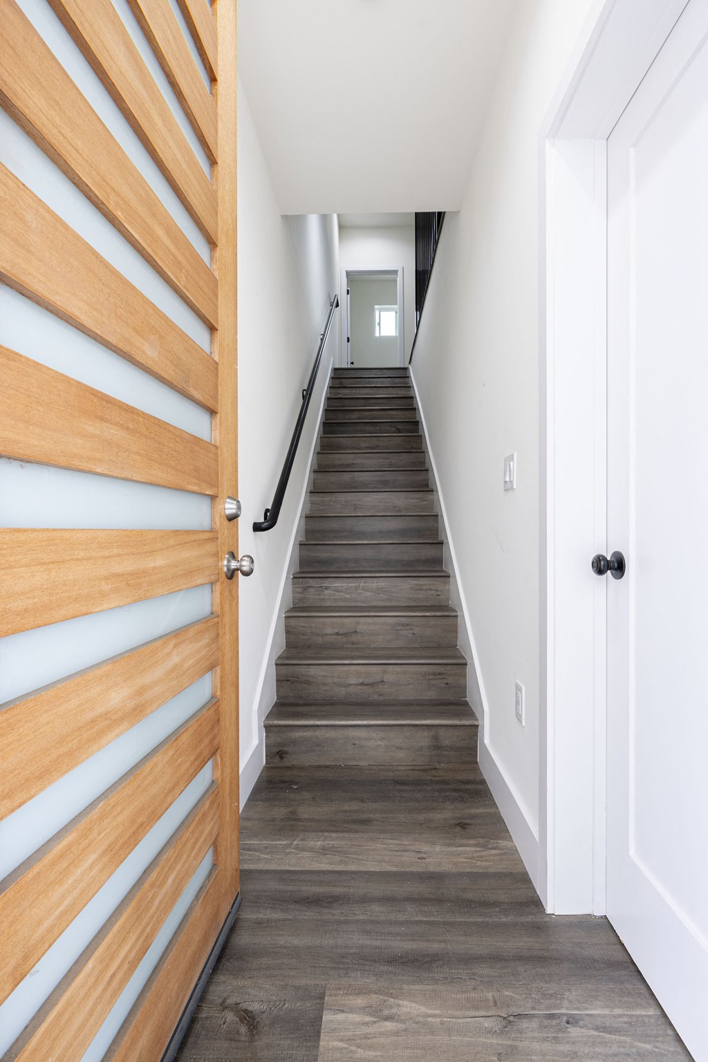 a staircase with wood floors and a wooden door
