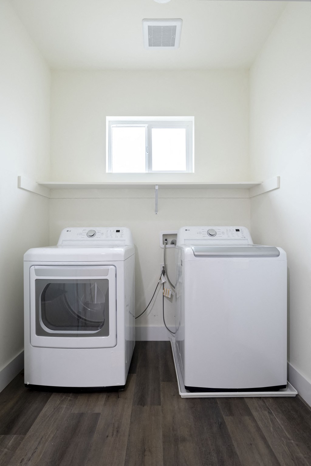 an empty room with two washes and a dryer in it