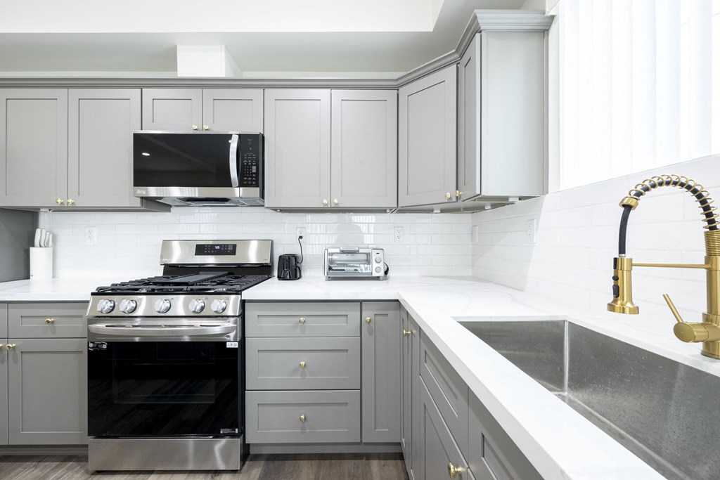 a white kitchen with stainless steel appliances and white cabinets