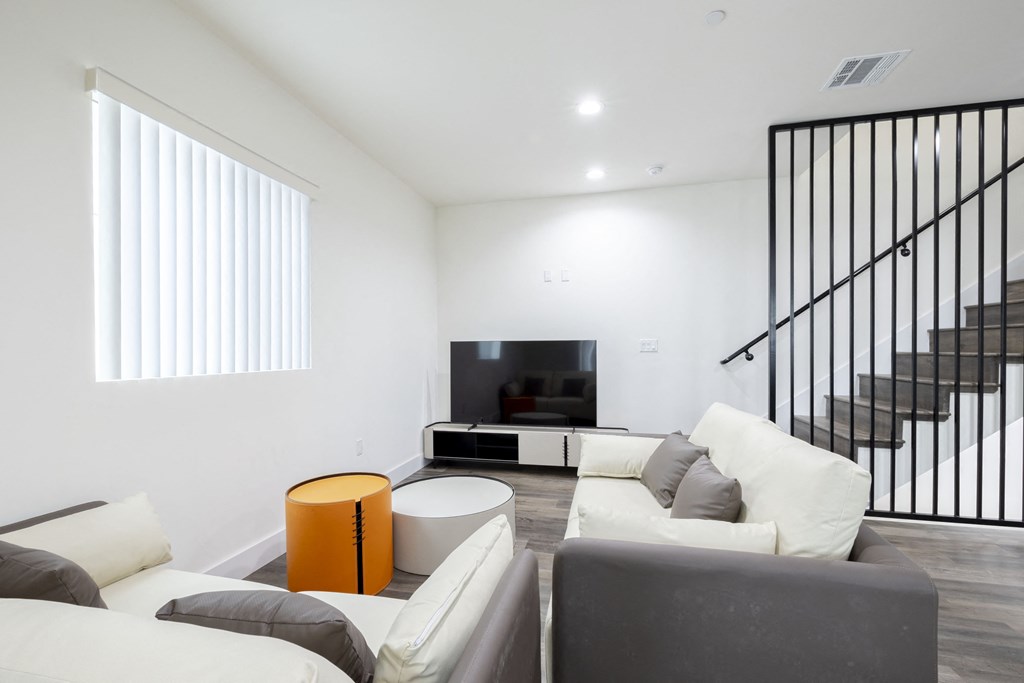 a living room with a white couch and a tv