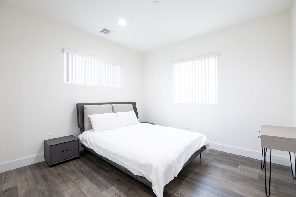 a white bedroom with a bed and a table