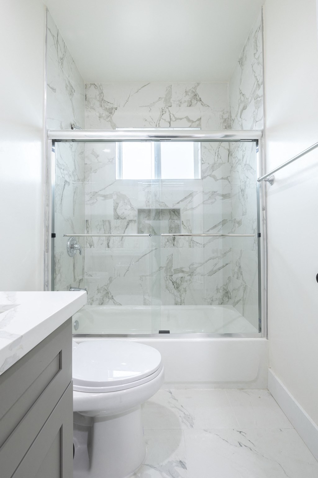 a white bathroom with a shower and a toilet