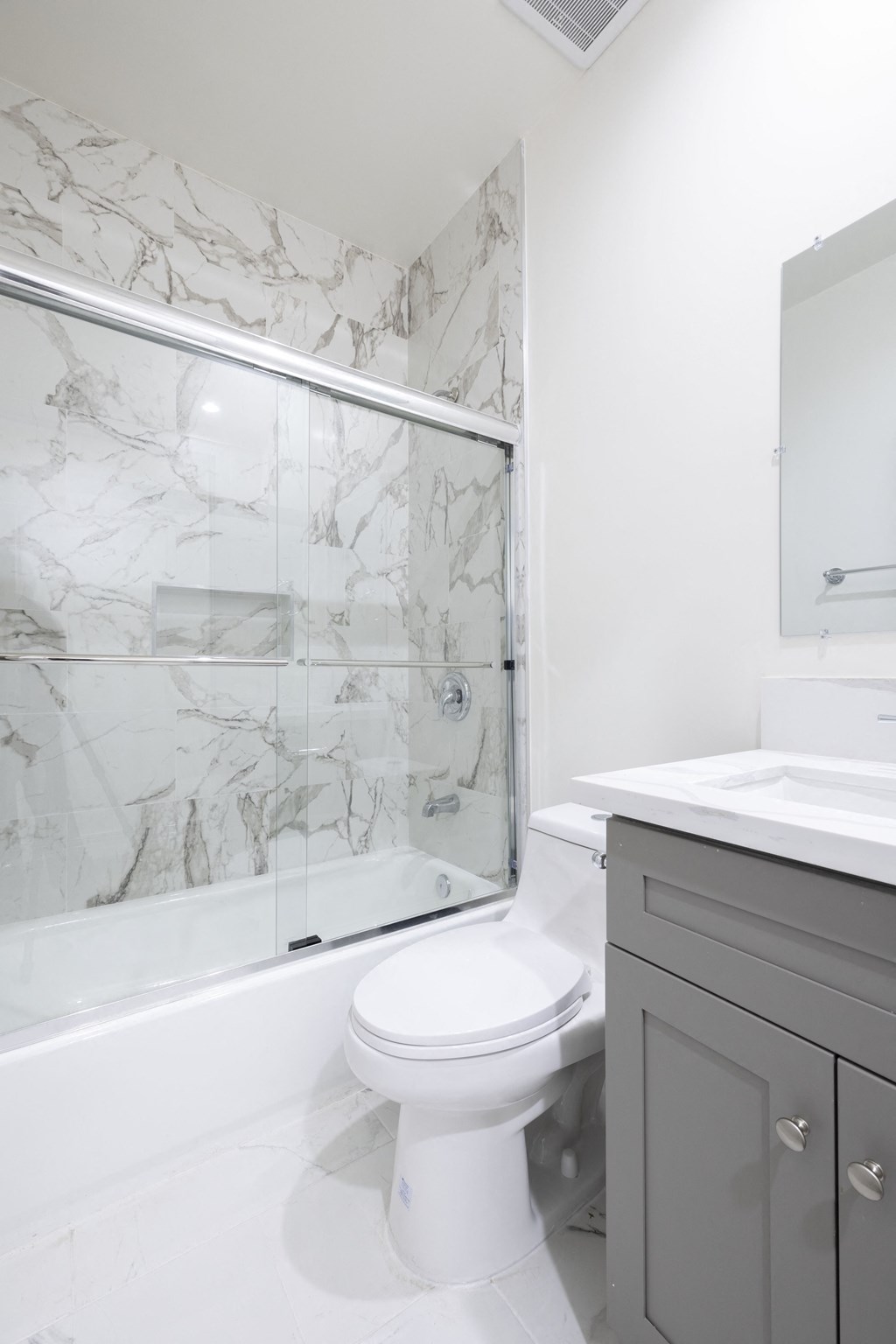 a white bathroom with a shower and a toilet