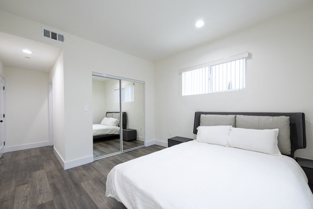 a bedroom with a large bed and a mirror