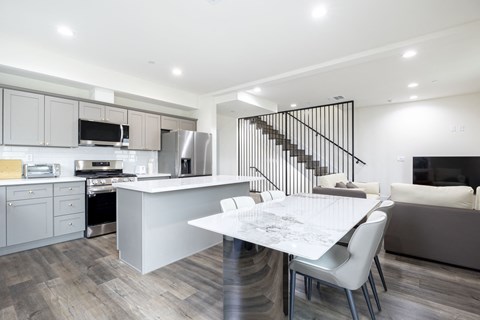 a white kitchen and dining room with a white table and chairs