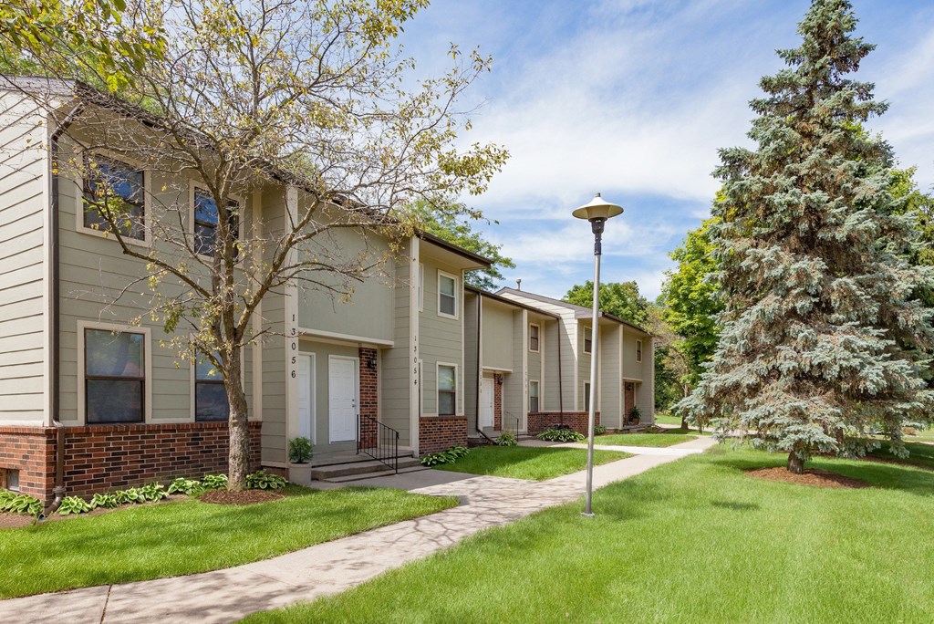 A row of houses with a tree in front of the first house.