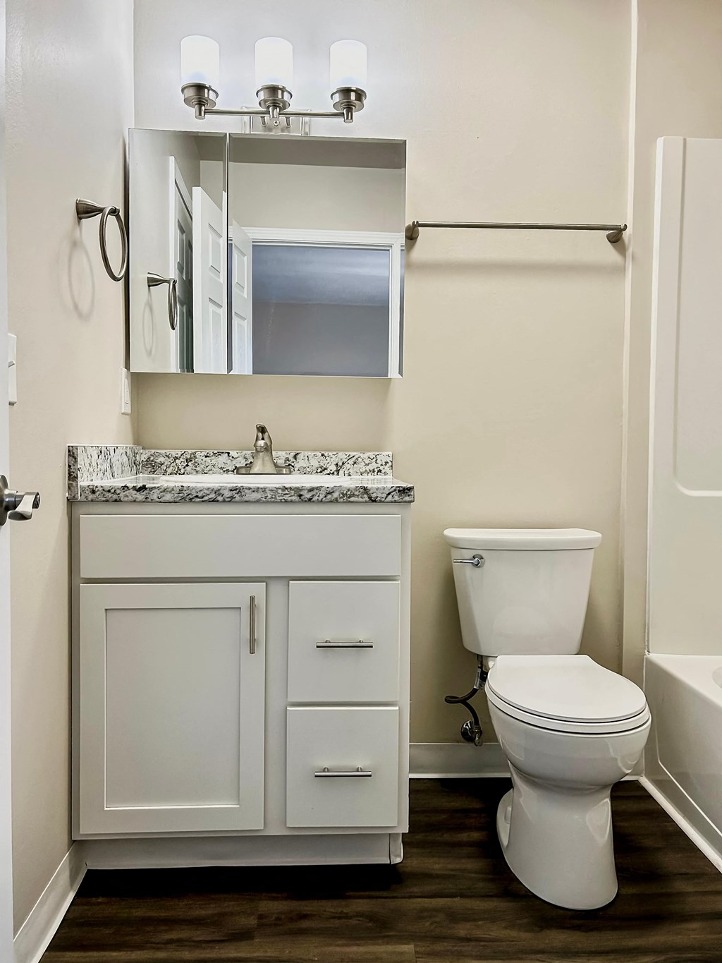 A white toilet sits next to a sink in a bathroom.