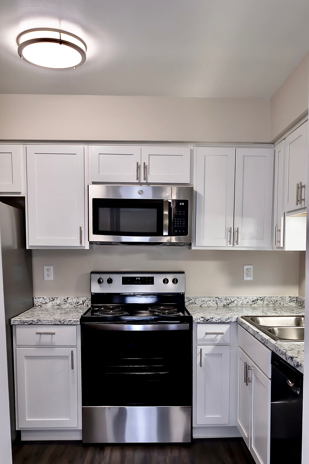 A kitchen with white cabinets and a black stove top oven.