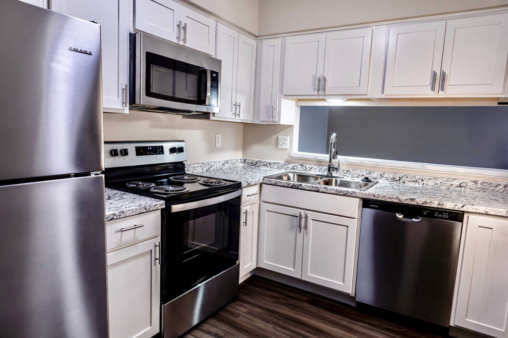 A kitchen with white cabinets and stainless steel appliances.