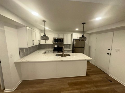 a kitchen with white cabinets and a white counter top