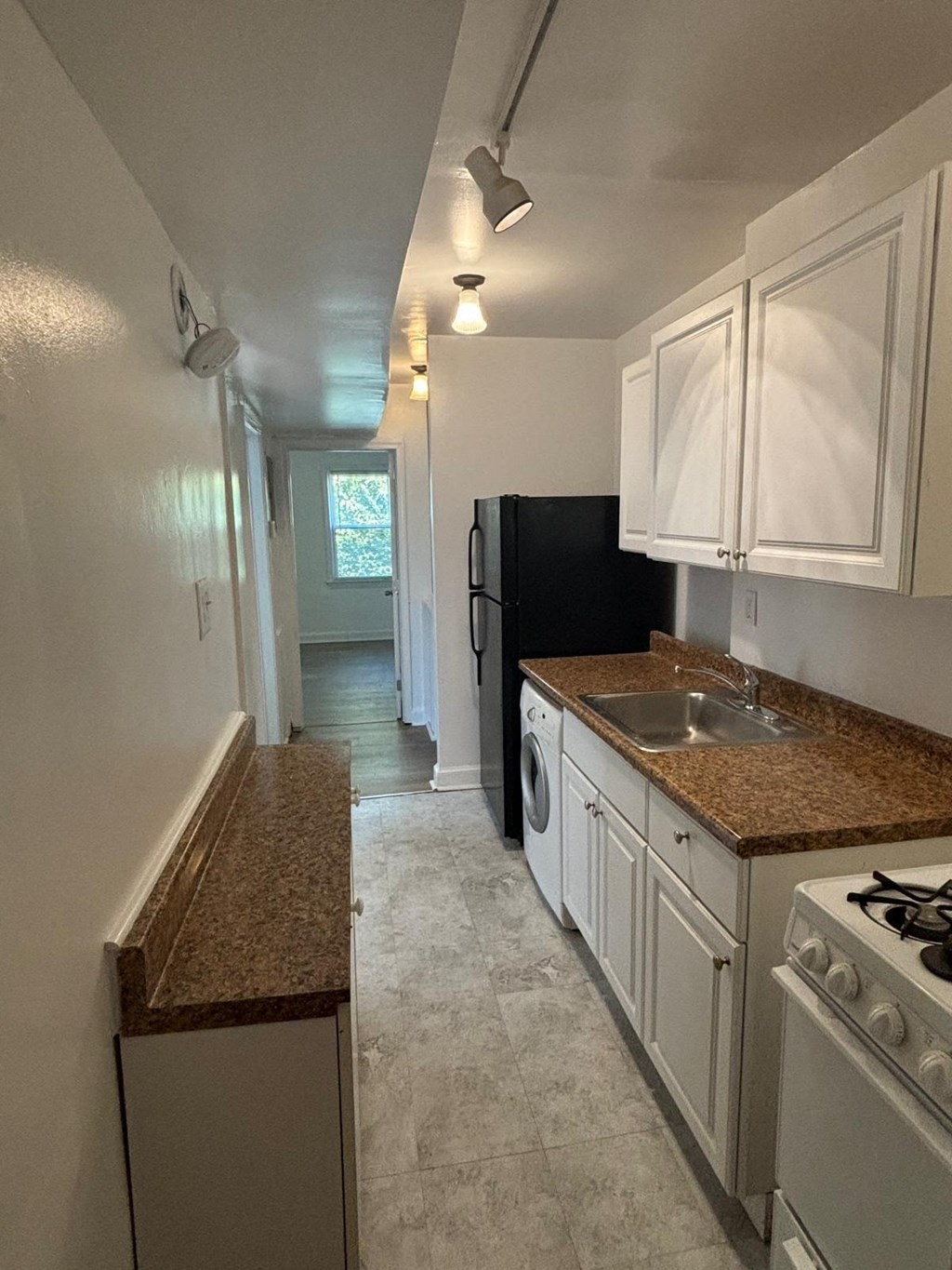 a kitchen with white cabinets and granite counter tops