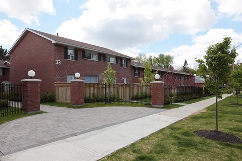 an apartment building with a sidewalk and a fence