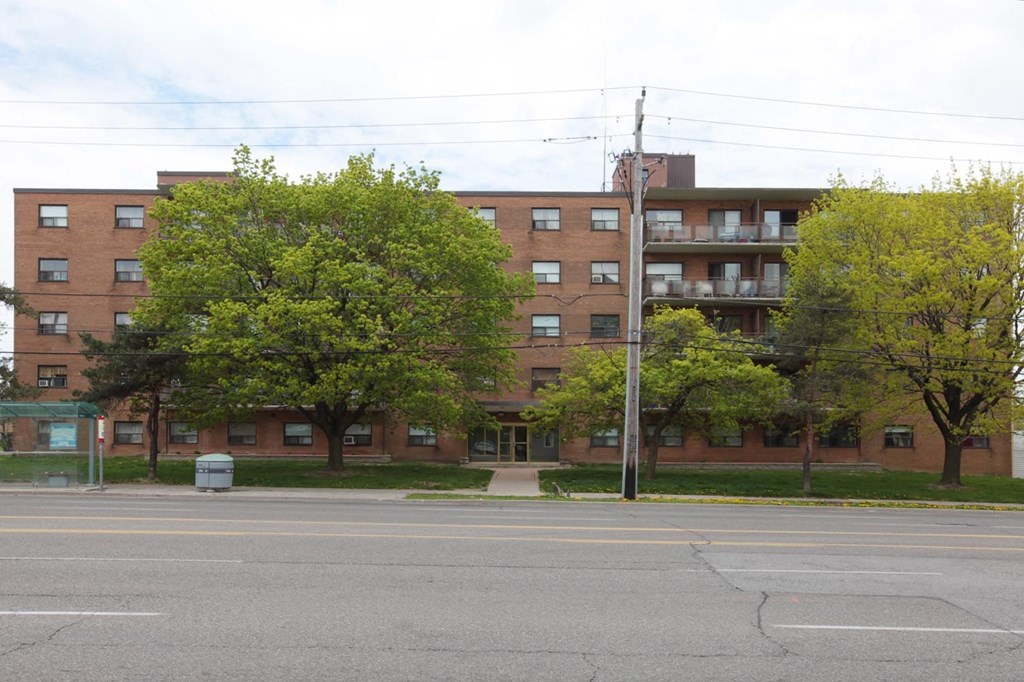 A large brick building with a parking lot in front.