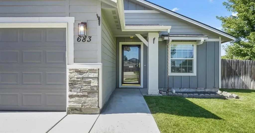 the front of a house with a sidewalk and a garage door