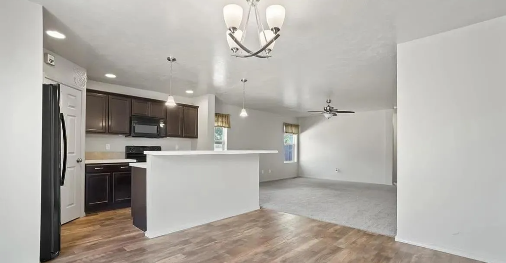 an empty kitchen and living room with a white counter top