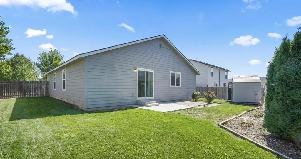 a white house with a grassy yard and a fence