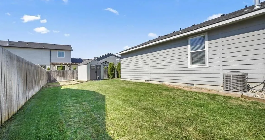 the backyard of a house with a yard and a fence