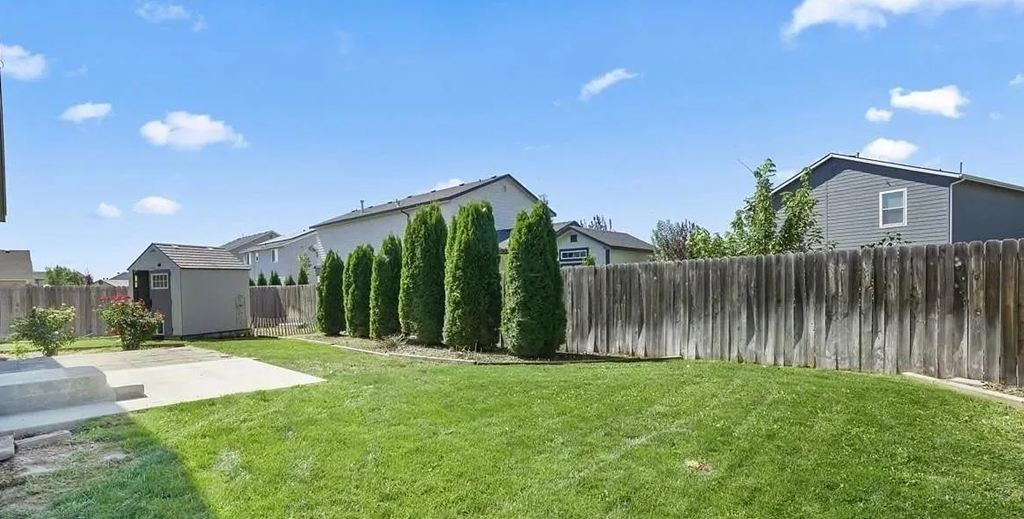 the backyard of a house with a yard and a fence