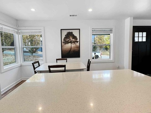 a dining room with a table and chairs in a room with windows