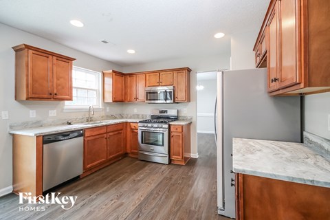 A kitchen with wooden cabinets and a marble countertop.