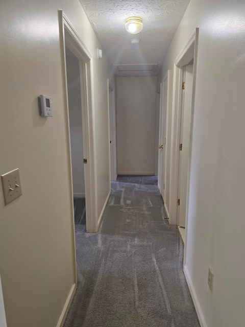A long, narrow hallway with a light on.