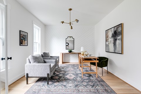 a living room with a couch and a desk and a rug