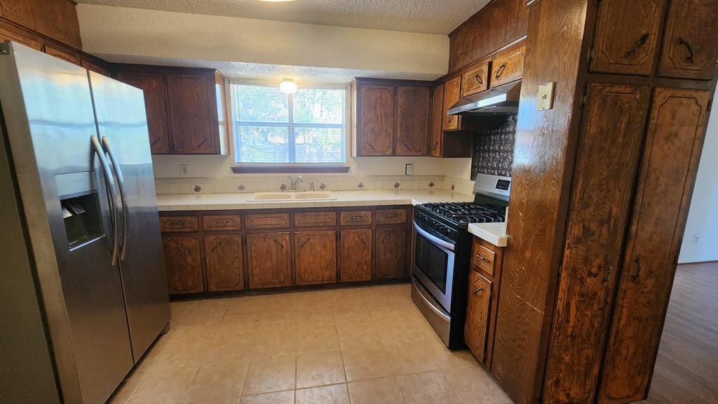 a kitchen with wooden cabinets and stainless steel appliances