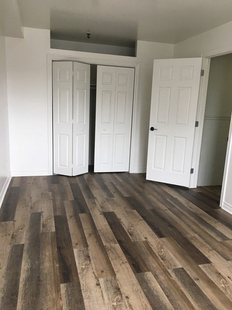 a living room with wood floors and white walls and doors