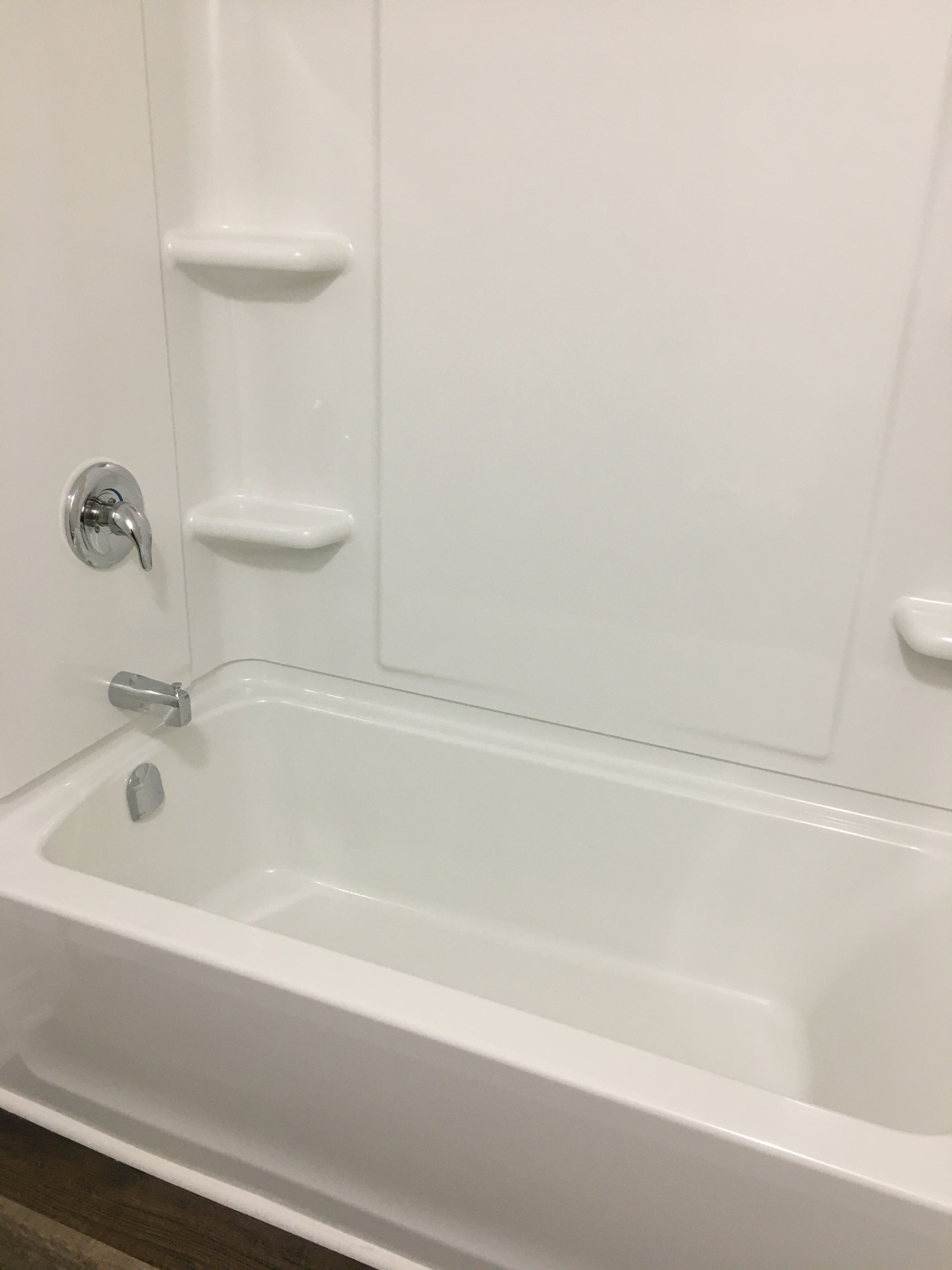 a white bathroom with a tub and a shower