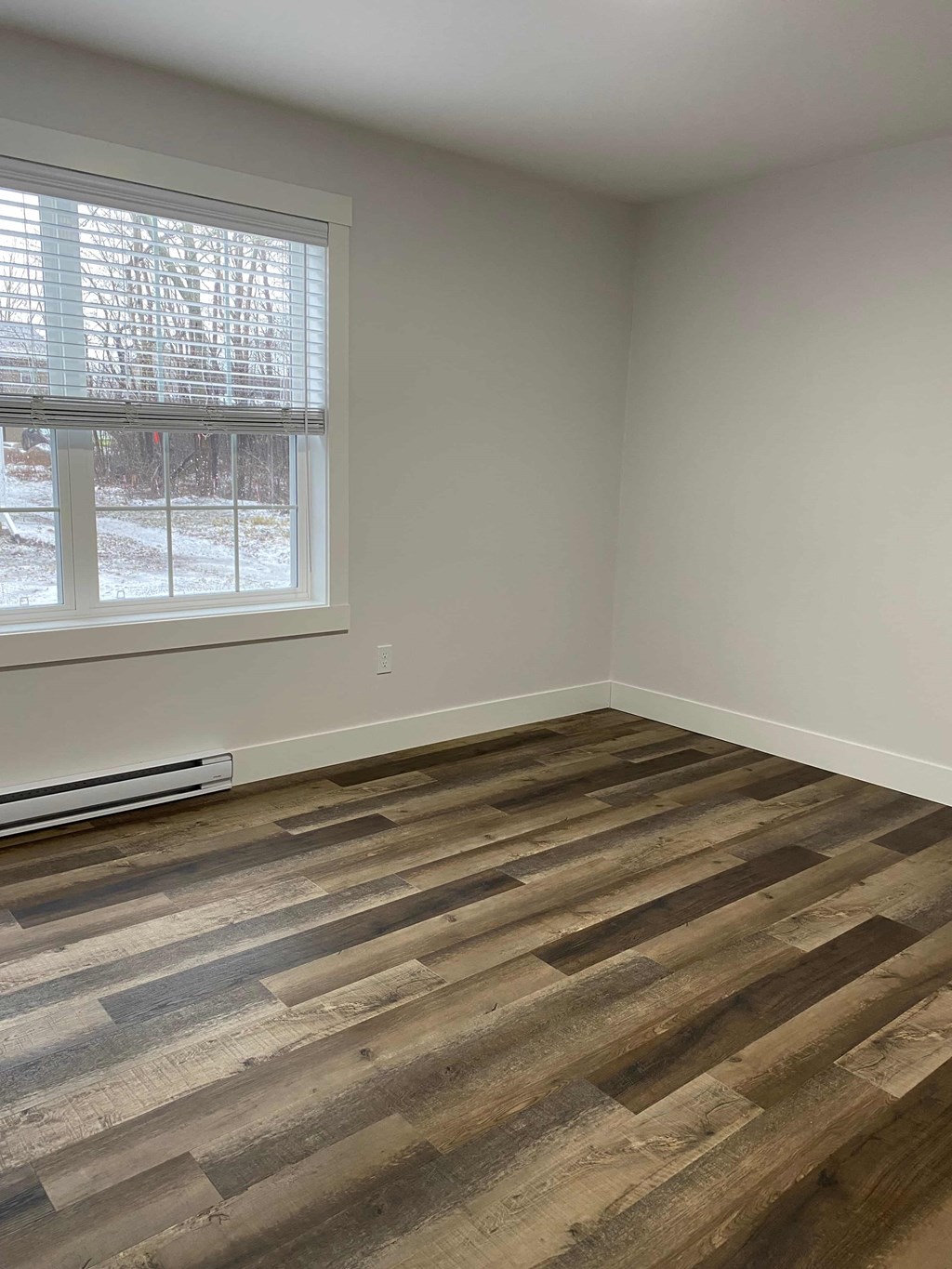 a living room with wood floors and a window