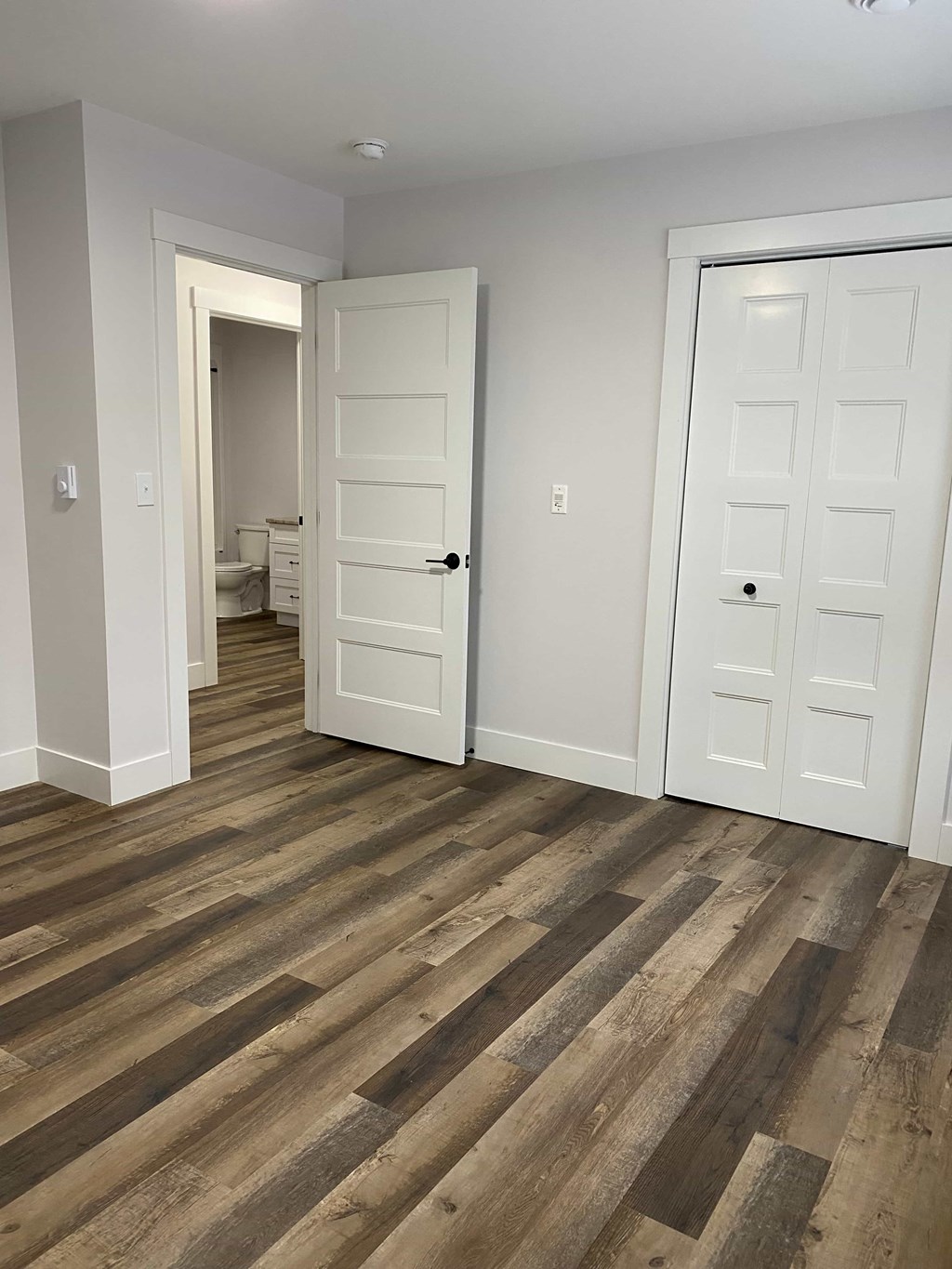 a living room with wooden floors and white doors